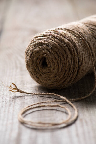 selective focus of untangled beige string on wooden background 