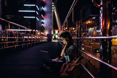 kadın şehir geceleri sokak üzerinde dizüstü bilgisayar kullanırken kulaklık müzik dinleme yan görünüm