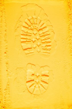 Ayakkabı izi üstten görünüm sarı tozu arka plan üzerinde