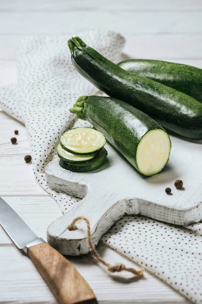 Klipp Och Hela Gröna Zucchini Vitt Trä Bord — Stockfoto