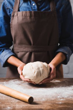 çiğ hamur pizza için elinde tutan önlük kadında doz kırpılmış