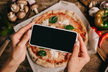 Ahşap yüzeyde kagit üzerinde pişmiş pizza resim çekmek gıda blogger kadeh kırpılmış