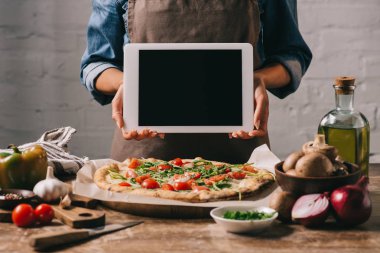 Gıda Blogger önlük tablet ile boş perde, Masa üstü İtalyan pizza ile tutarak atış kırpılmış