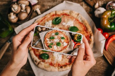 Ahşap yüzeyde kagit üzerinde pişmiş pizza resim çekmek gıda blogger kadeh kırpılmış
