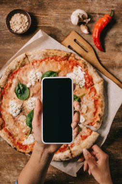 Ahşap yüzeyde kagit üzerinde pişmiş pizza resim çekmek gıda blogger kadeh kırpılmış