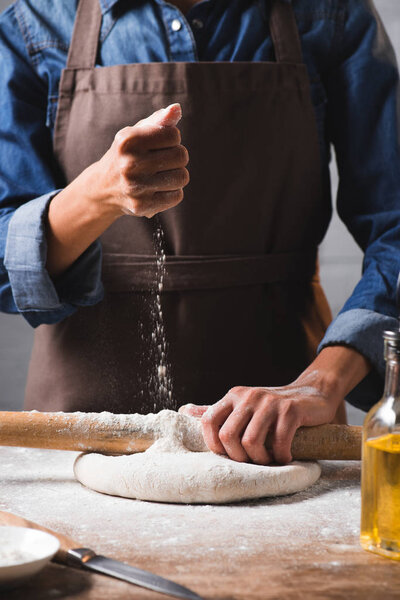 partial view of woman kneading dough for pizza