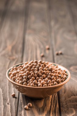 ahşap masa üzerinde sağlıklı çiğ nohut ile kase görünümünü kapat