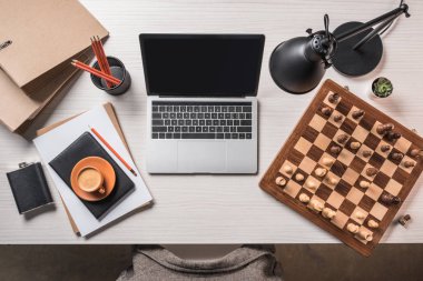 çalışma alanı satranç tahtası, kahve, dizüstü bilgisayar ve Kırtasiye ile üstten görünüm tablo