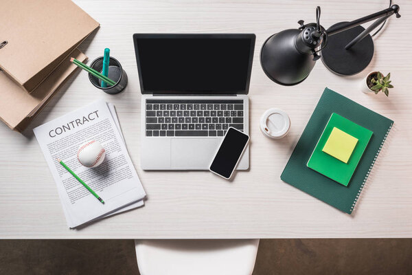 top view of contract, baseball ball, gadgets and stationery on working table 