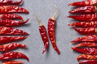 top view of dried red chili peppers arranged on grey tabletop