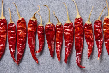 top view of red chili peppers arranged on grey tabletop