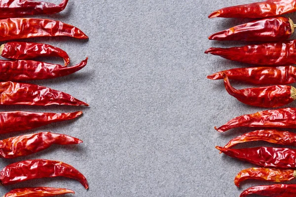 在灰色桌面上排列的干红辣椒的顶部视图 — 图库照片