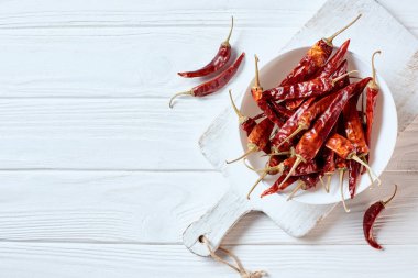 Kurutulmuş kırmızı biber kase üstten görünüm beyaz kesme tahtası Ahşap yüzeyi Tarih