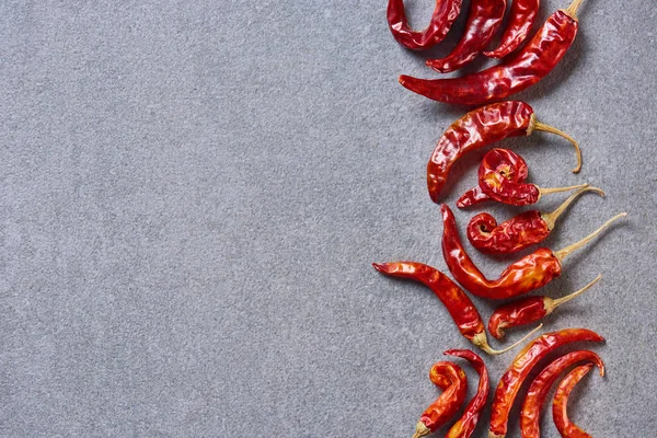 红色干辣椒的顶部视图在灰色桌面上排列 — 图库照片