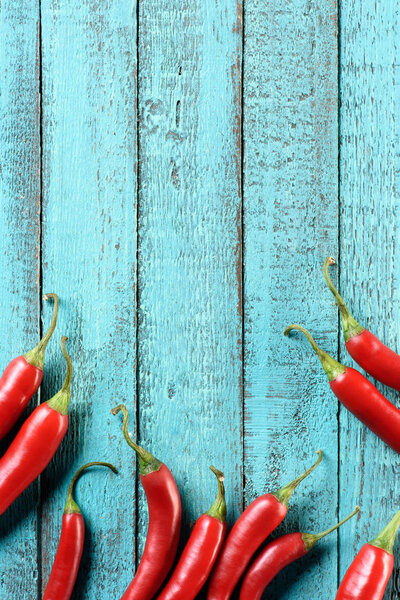 elevated view of red ripe chili peppers on blue wooden table