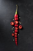 Картина, постер, плакат, фотообои "elevated view of cut red ripe chili pepper on black surface", артикул 210840250