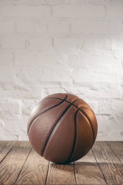 ahşap zemin üzerinde bir kahverengi basketbol topu