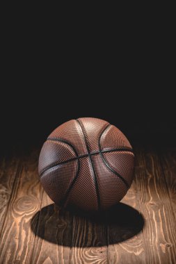 karanlık odada ahşap zemin üzerinde bir kahverengi basketbol topu