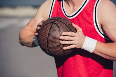 cropped image of sportsman playing basketball on street clipart