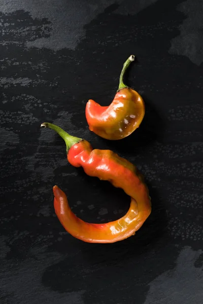 Top View Two Chili Peppers Black Surface — Free Stock Photo