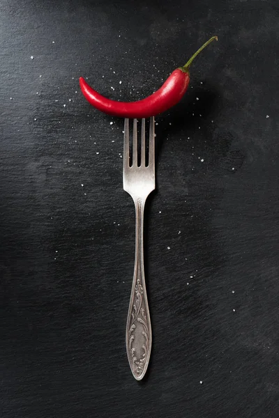 黒の表面上の赤熟した唐辛子とフォーク トップ表示 — ストック写真