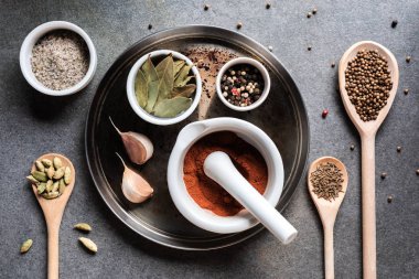 top view of various aromatic dried seasonings on grey surface   clipart