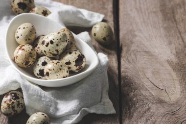 kumaş ve plaka sağlıklı Bıldırcın yumurta rustik ahşap masa üzerinde görmek 