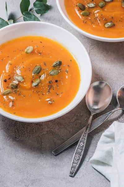 Close up view of plates with pumpkin cream soup with seeds on table — Stock Image Close View Plates Pumpkin Cream Soup Seeds Table Stock Photo