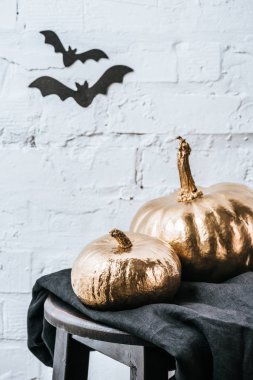 halloweenclose-up vurdu iki halloween pumpkins yarasa çıkartmaları ile beyaz tuğla duvar önünde altın metalik boyalı