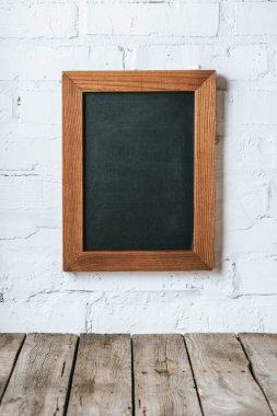 boş yazı tahtası bakış beyaz tuğla duvar ve ahşap plakalar yüzey üzerinde kapatın