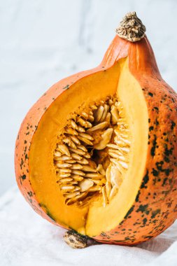 close up view of ripe pumpkin on white brick wall background clipart