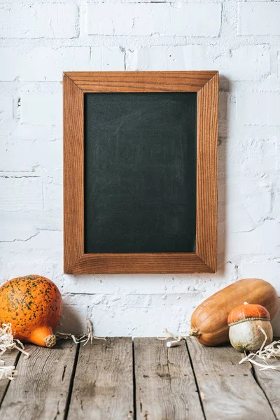 Close Van Ruwe Pumpkins Houten Tafelblad Leeg Schoolbord Hangend Aan — Stockfoto