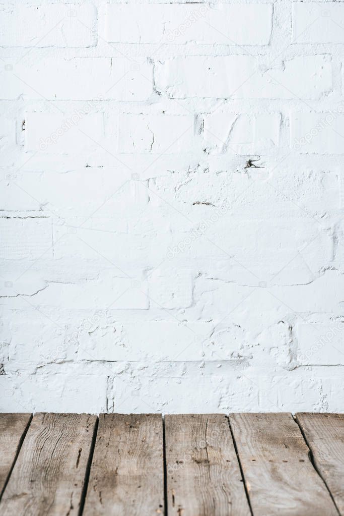 close up view of wooden planks and white brick wall background