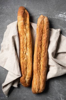 top view of baguettes on linen on grey tabletop clipart
