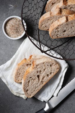 düz lay kesme somun ekmek, bıçak ve gri masa üzerinde beyaz keten ile