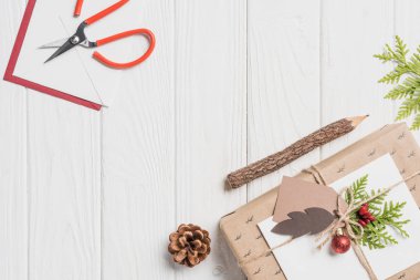 baubles, herdem yeşil koni ve makas ile dekore edilmiş Noel hediyesi üstten görünüm ahşap tablo