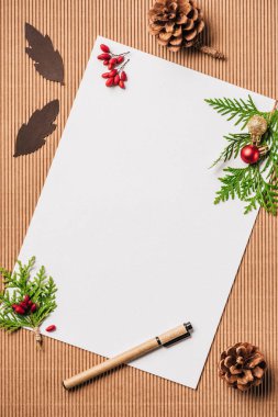 yüzey üzerinde boş kağıt ve evergreen dalları Noel baubles ile üstten görünüm