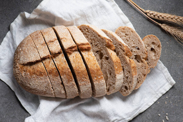 flat lay with cut loaf of bread on white linen on grey tabletop