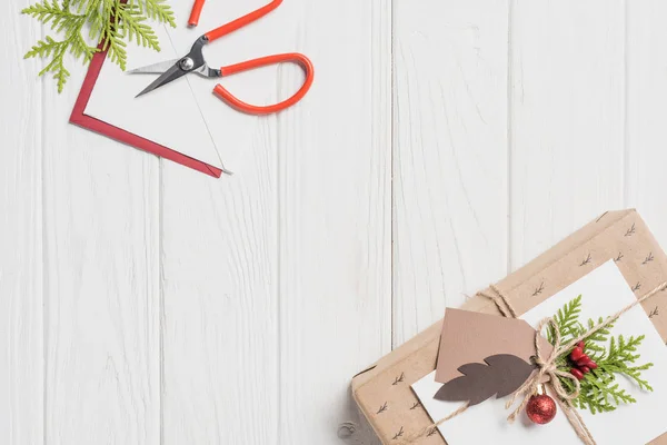 Erhöhter Blick Auf Geschmücktes Weihnachtsgeschenk Mit Kugeln Auf Holztisch — Stockfoto