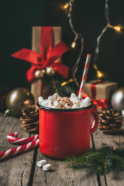 cup of hot cocoa with marshmallows on wooden table with christmas decor