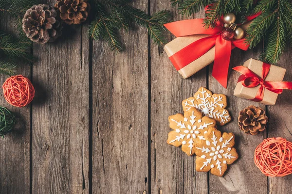 kopya alanı ile ahşap arka plan üzerinde gingerbread kar taneleri ve Noel hediyeleri üstten görünüm