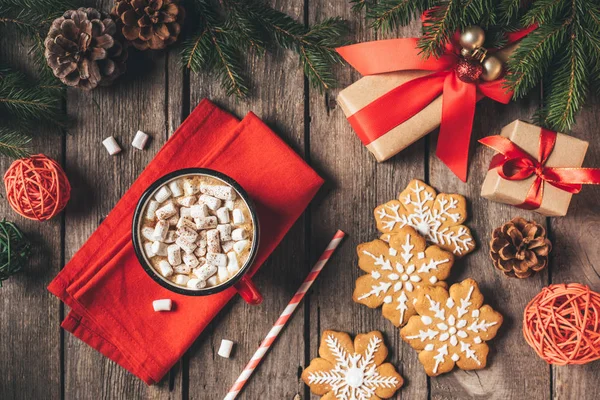 モミの木と木製の背景にジンジャーブレッド クリスマス プレゼントやマシュマロとココアのカップの上から見る — ストック写真