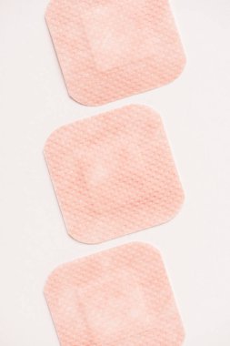 top view of row of adhesive bandages on white surface clipart