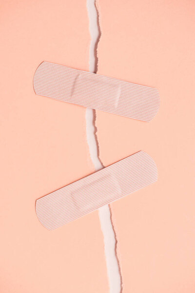top view of adhesive bandages holding two parts of torn paper