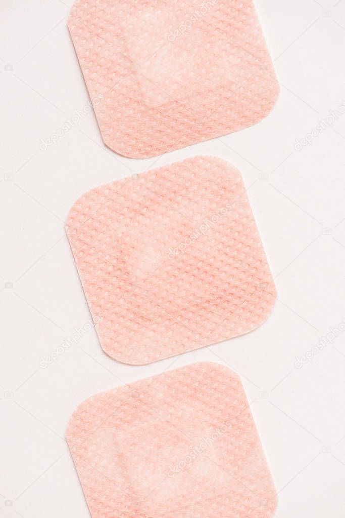 top view of row of adhesive bandages on white surface