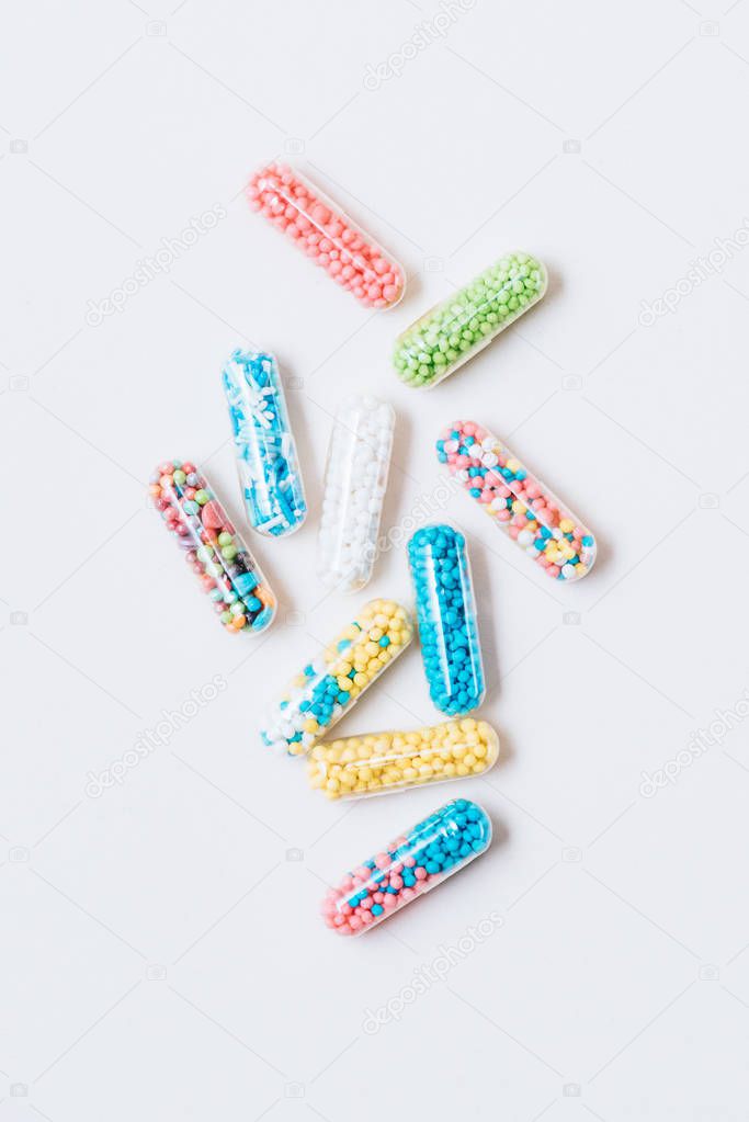 top view of different colorful medical capsules on white