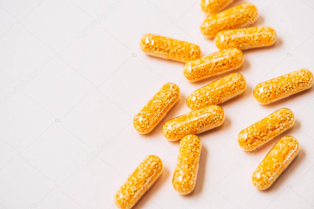 close-up shot of yellow medical capsules on white