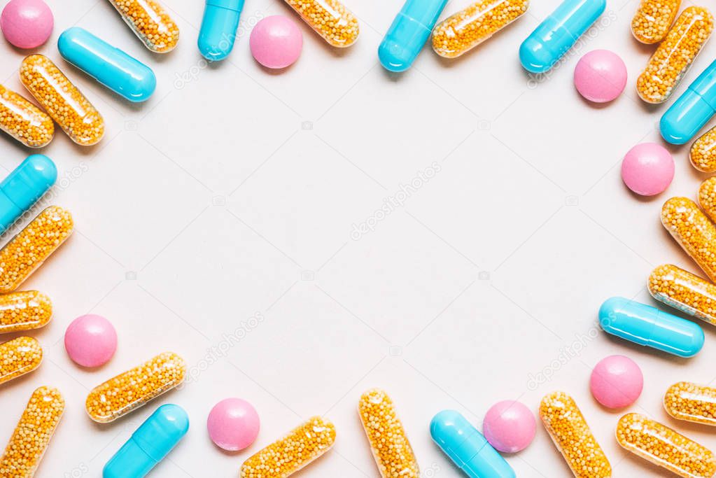 top view of frame made of various colorful pills on white surface