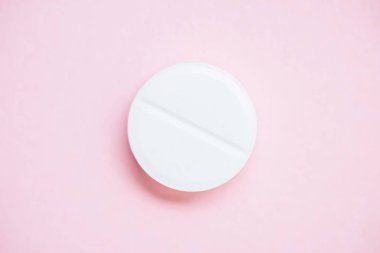 top view of medical pill on pink surface