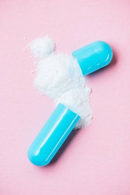 yakın çekim çekim ile dökülen toz pembe üzerinde kırık tıbbi kapsül